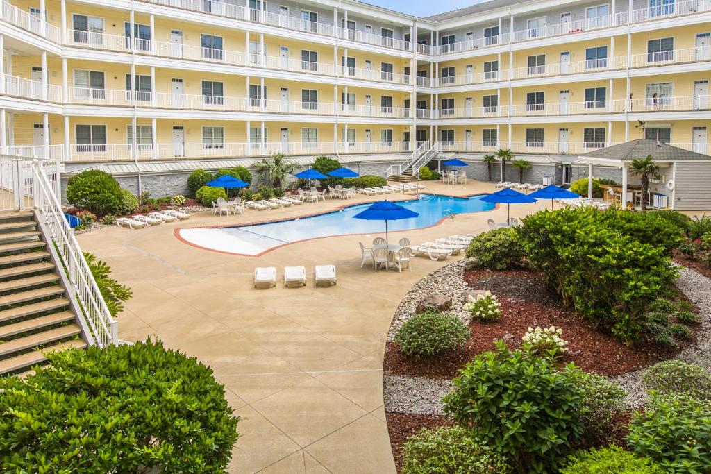 弗吉尼亚海滩The Sandbridge Dunes - Captains' Quarters 408的公寓大楼设有游泳池、椅子和遮阳伞