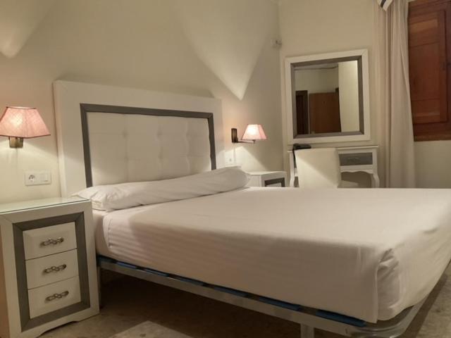 兰哈龙Hotel el Sol的卧室配有一张白色大床和镜子