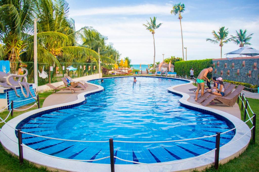 马拉戈日Pousada Polymar的度假村的游泳池,人们在里面玩耍
