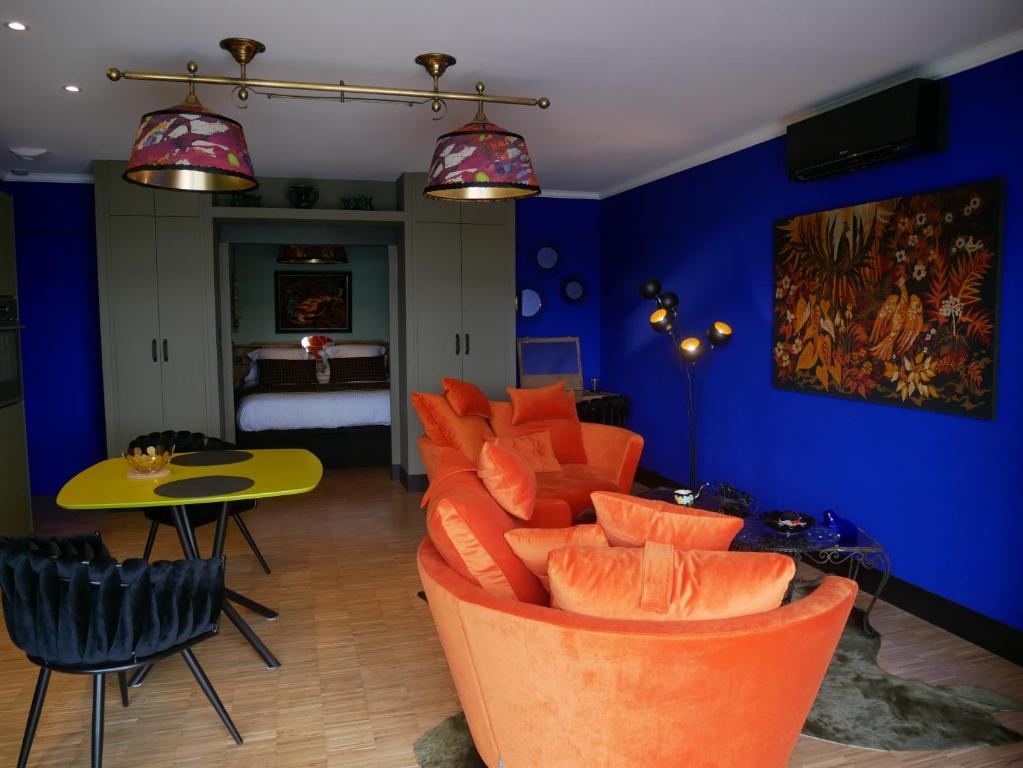 欧布纳Suite 24的客厅配有橙色椅子和蓝色墙壁