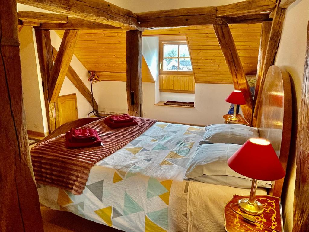 维勒塞瑟尔Manoir Saint-Pierre的一间卧室配有一张带红灯的大床