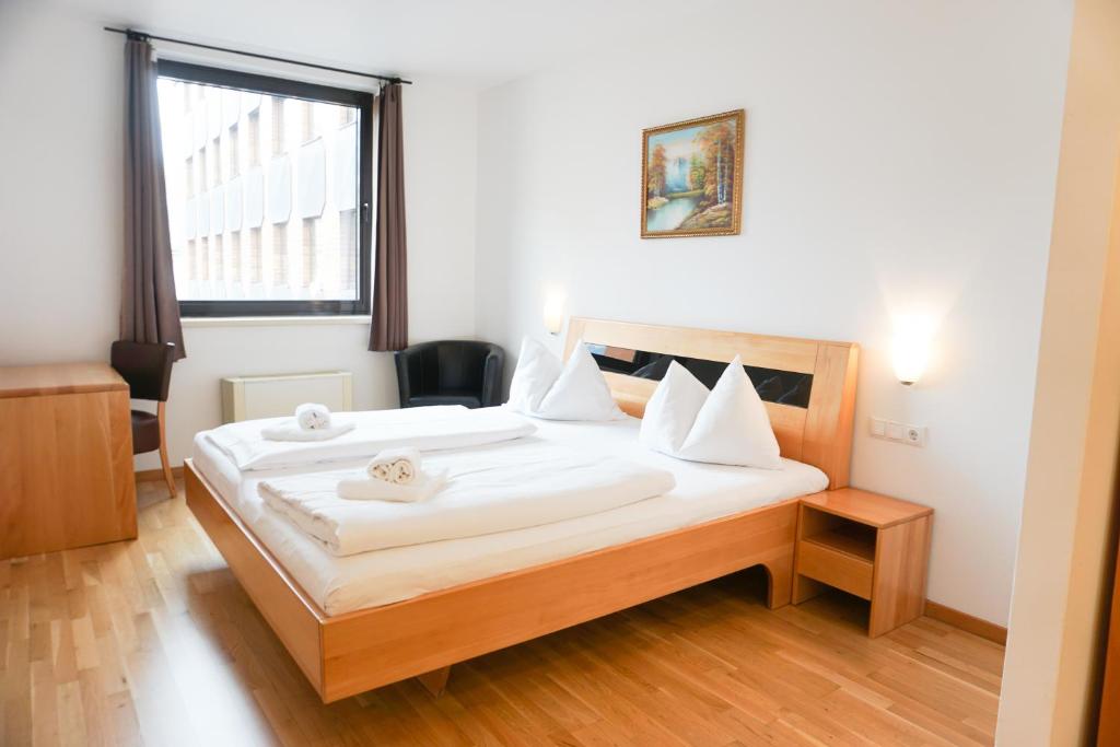 维也纳Hotel Kaffeemühle的一间卧室配有一张带白色床单的床和一扇窗户。