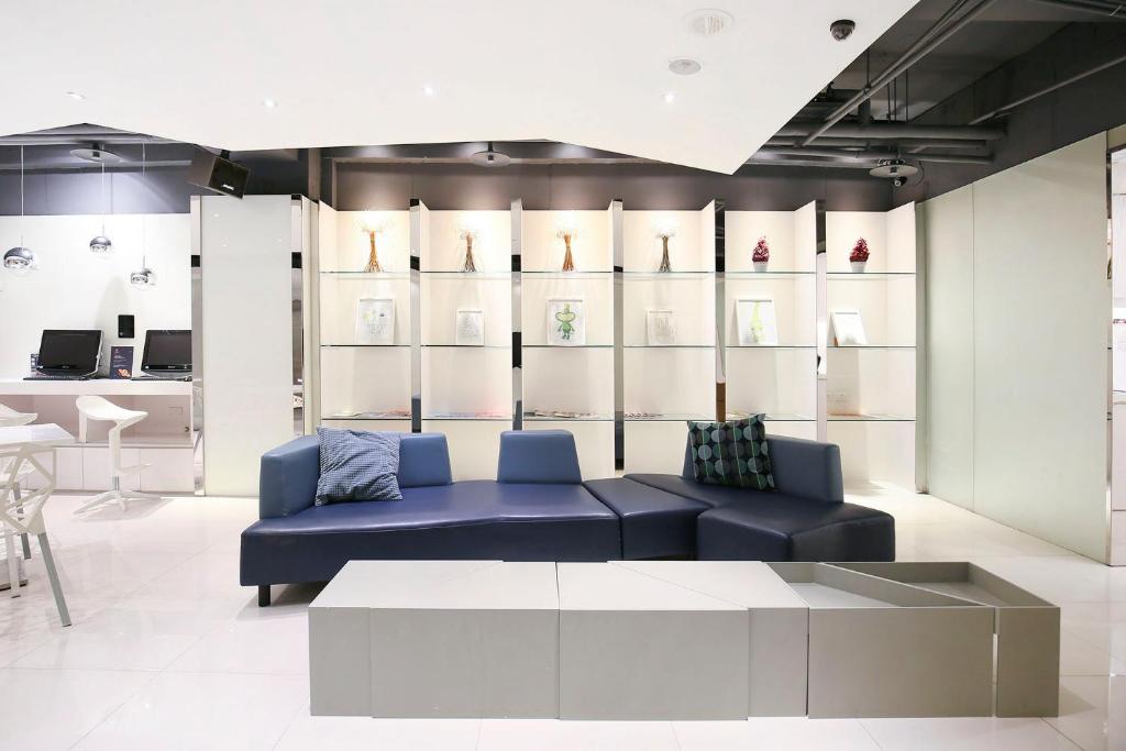 台北新驿旅店西门捷运店的客厅配有蓝色的沙发和桌子