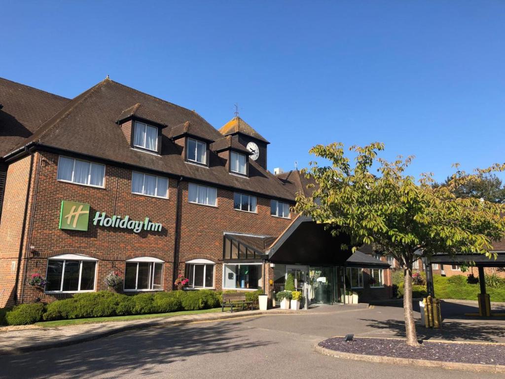 阿什福德Holiday Inn Ashford - North A20, an IHG Hotel的一座大型红砖建筑,上面有时钟