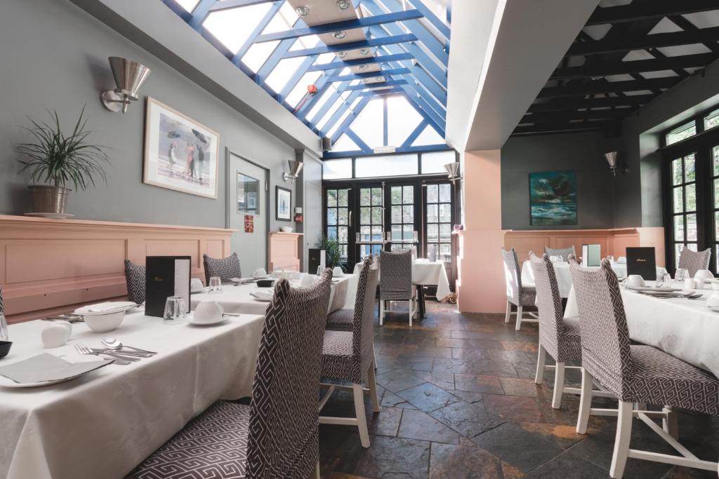 爱丁堡多尼亚同乐会酒店的用餐室设有桌椅和窗户。