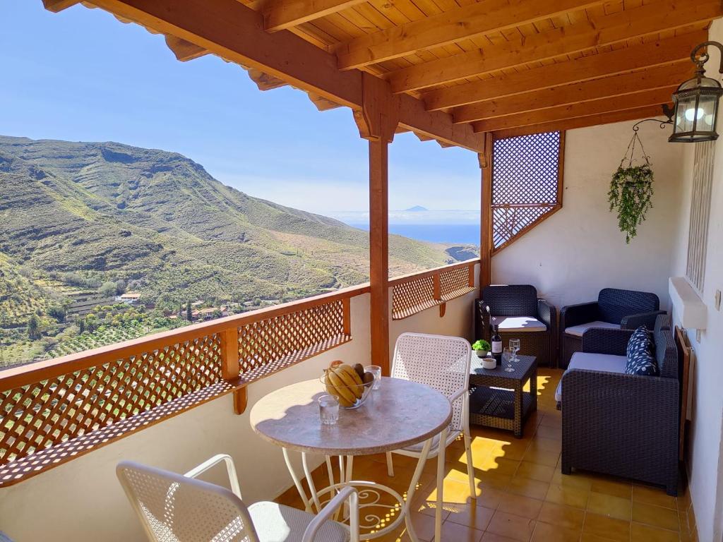 San PedroLa Casita de Agaete的设有一个配有桌椅并享有美景的阳台。