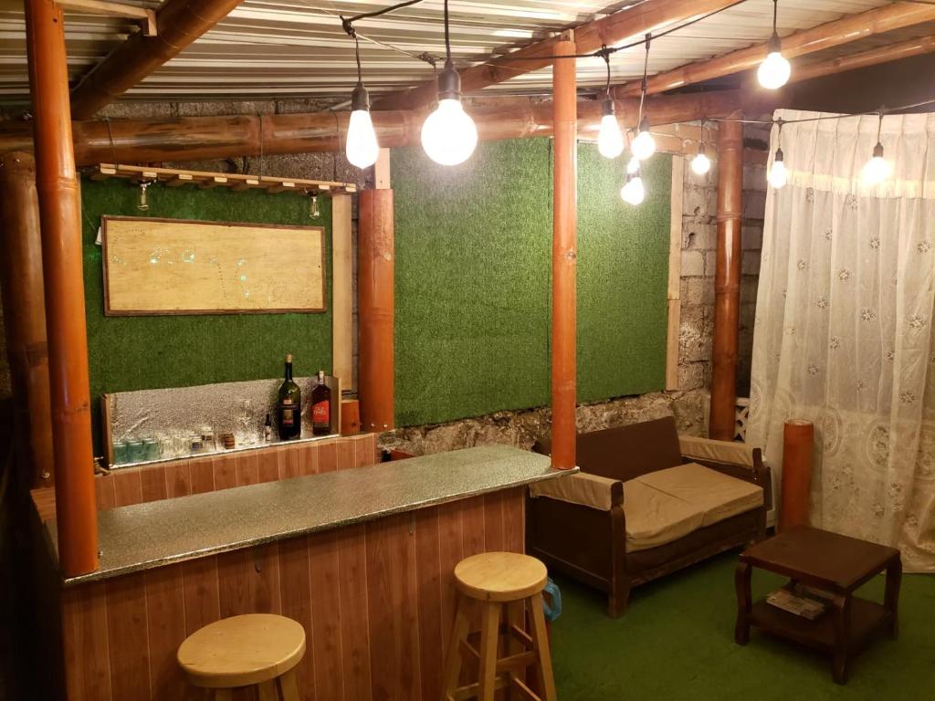 基多CASA VIEJA del Centro Historico的一个带绿色墙壁和一些凳子的酒吧