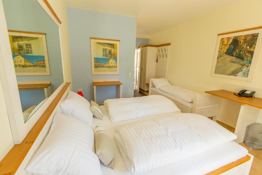 贡特拉姆斯多夫埃利亚酒店的一间房间,里面设有三张白色的床
