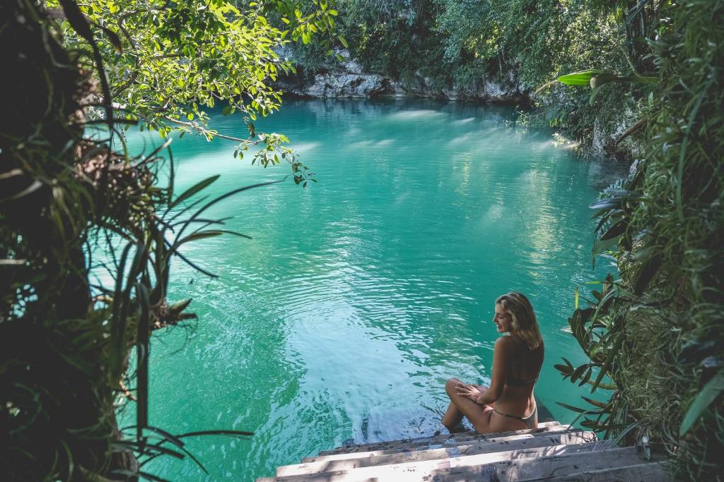 图卢姆Wakax Hacienda - Cenote & Boutique Hotel的坐在水体中的女人