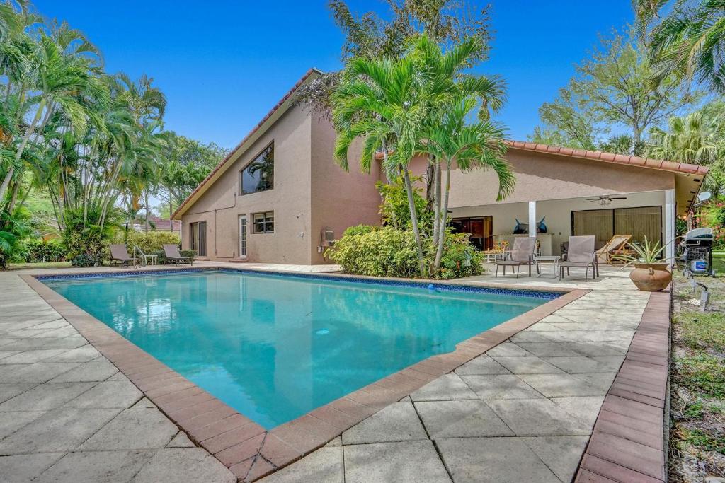帕诺滩Modern 6br Villa Resort Style Pool On Golf Course的棕榈树屋前的游泳池