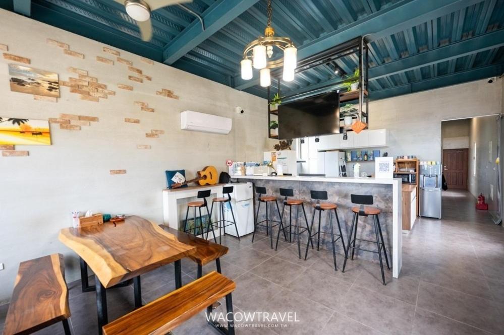 小琉球岛小琉球流浪背包客栈的厨房配有柜台和带凳子的酒吧