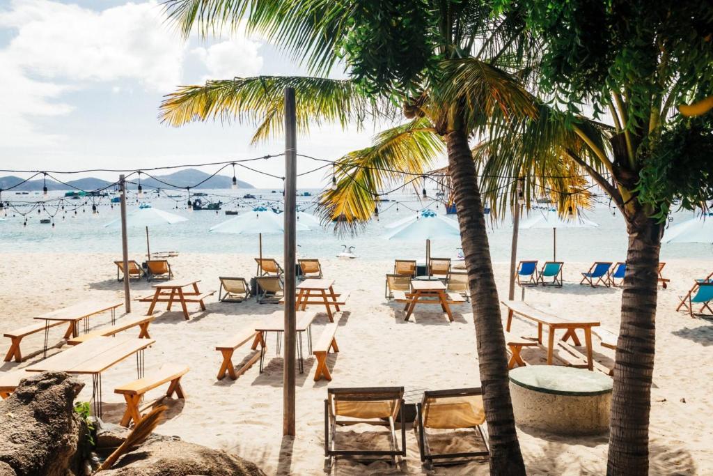 金兰Villa Đảo Hoa Vàng Cam Ranh - Venuestay的棕榈树海滩,沙滩上摆放着桌椅