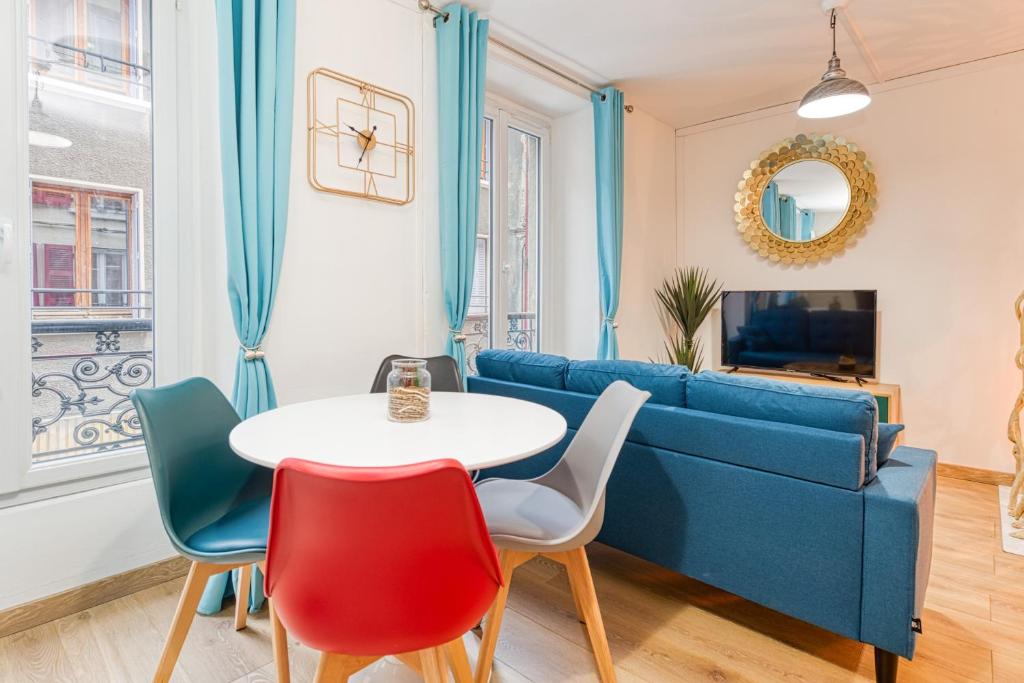 阿勒瓦尔Bien-être et bonheur au pied des Thermes的客厅配有蓝色的沙发、桌子和椅子