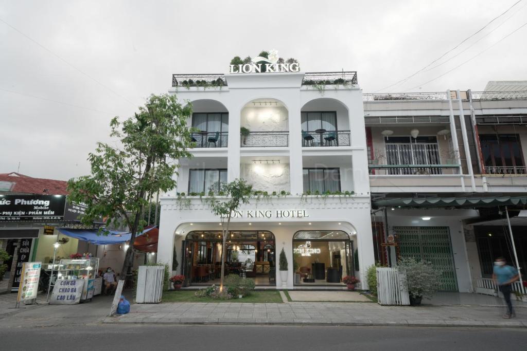 会安Lion King Hotel的街上有商店的白色建筑