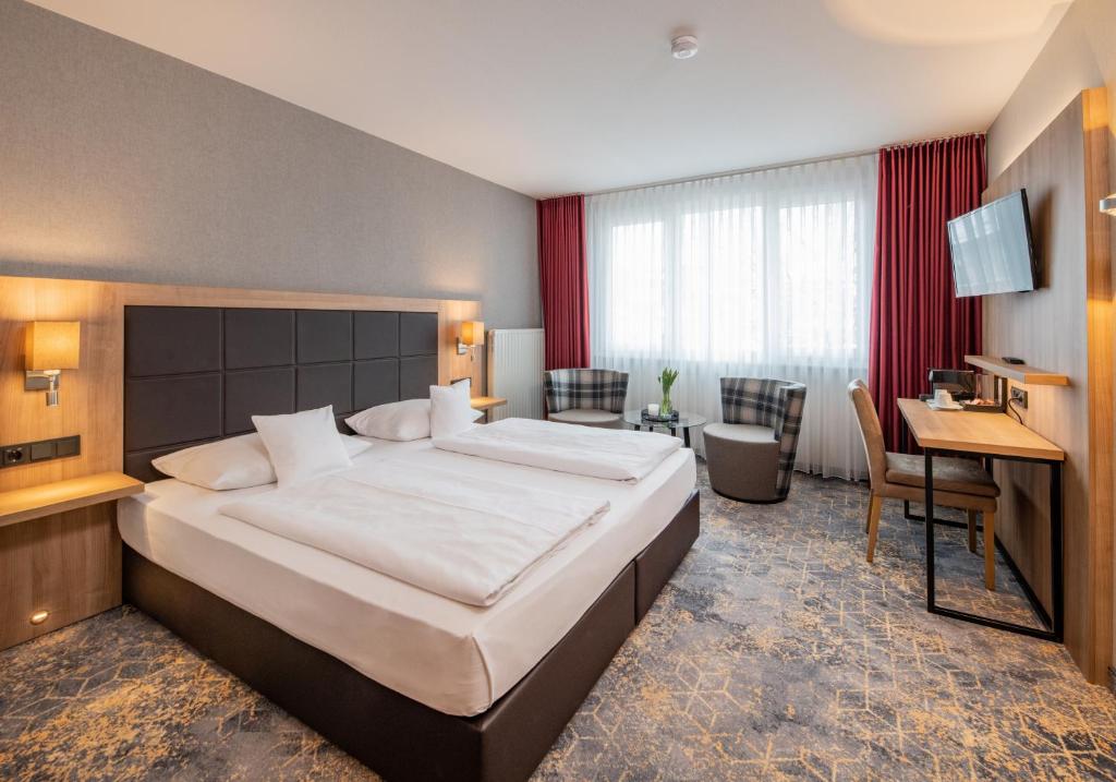 艾森纳赫哥布尔所芬酒店的酒店客房设有一张大床和一张书桌。