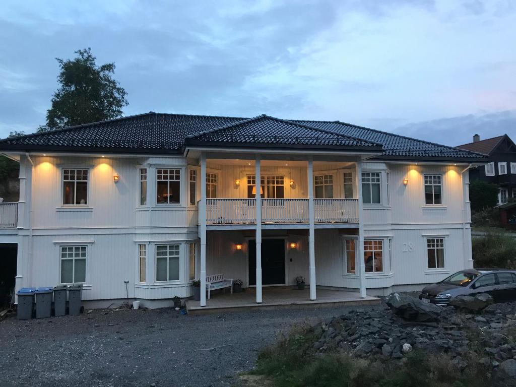 卑尔根Villa Klæboe的一座大型白色房子,前面有一辆汽车