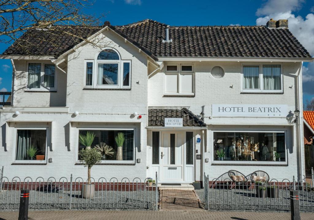 德科赫Hotel Beatrix的白色的房子,上面有酒店优惠标志
