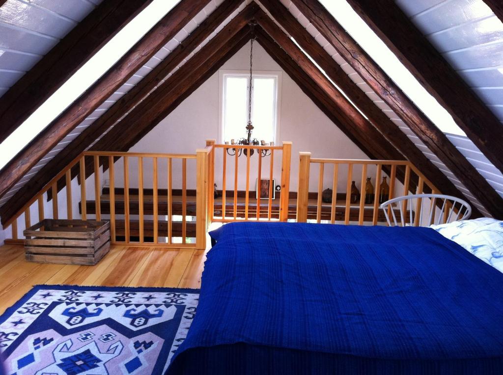 赫加奈斯Hönshuset Kullabygden的阁楼卧室配有蓝色床