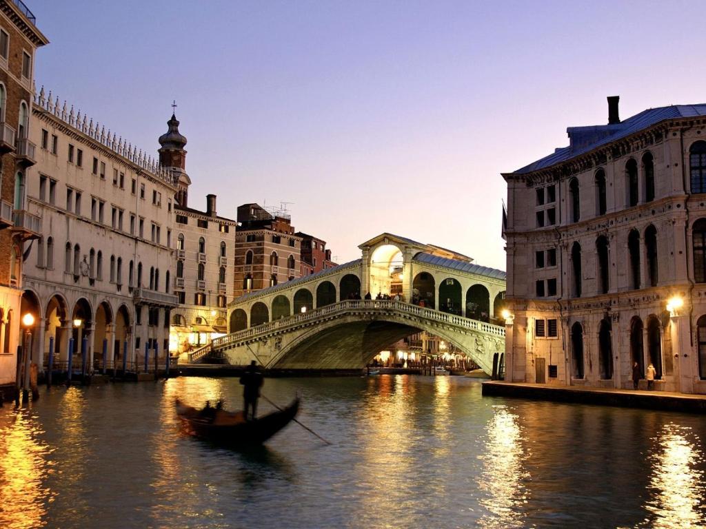 威尼斯艾博特利酒店的河上一座桥,水中有一船