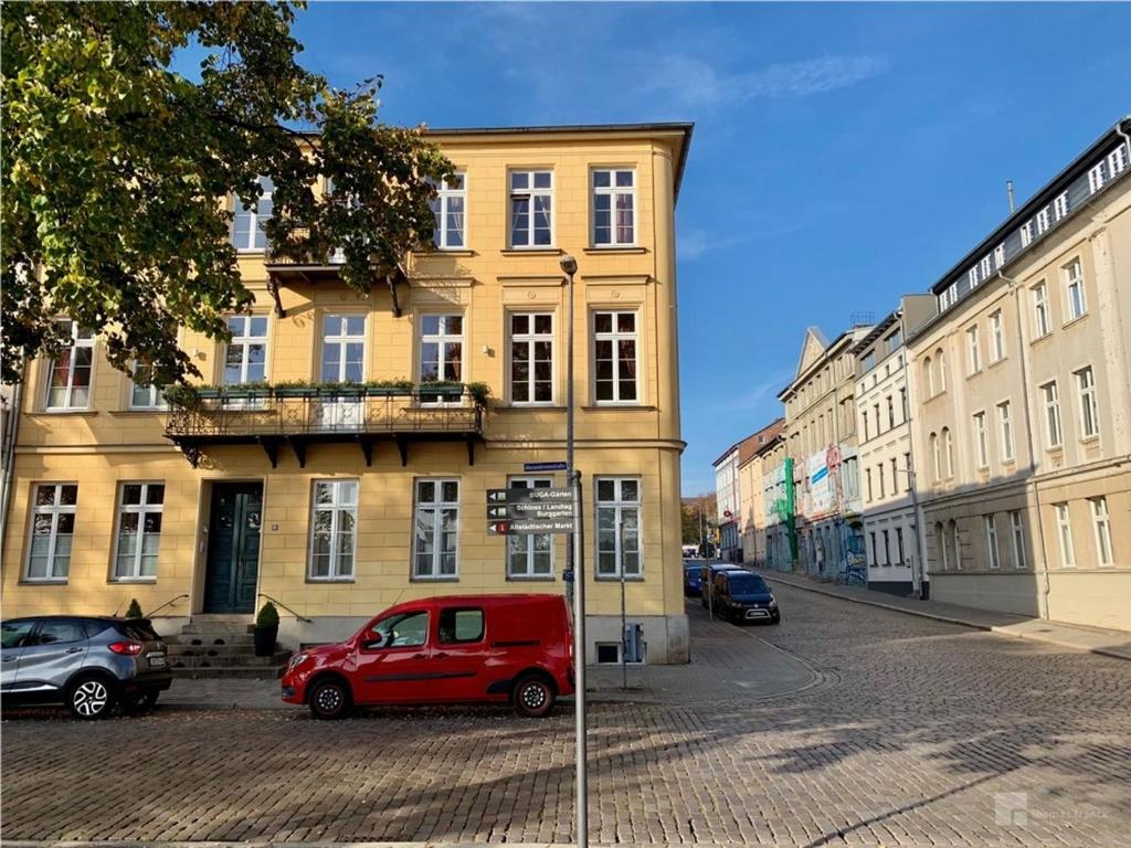 什未林Das Ferienapartment Alexandrine direkt am Pfaffenteich mit eigenem Parkplatz的停在大楼前的一辆红色货车