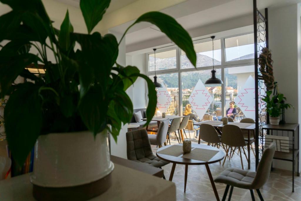 特雷比涅Herceg Vila的一间设有桌椅和盆栽的餐厅