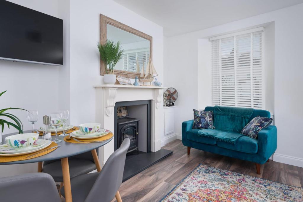 佩恩顿April Cottage的客厅配有绿色沙发和桌子