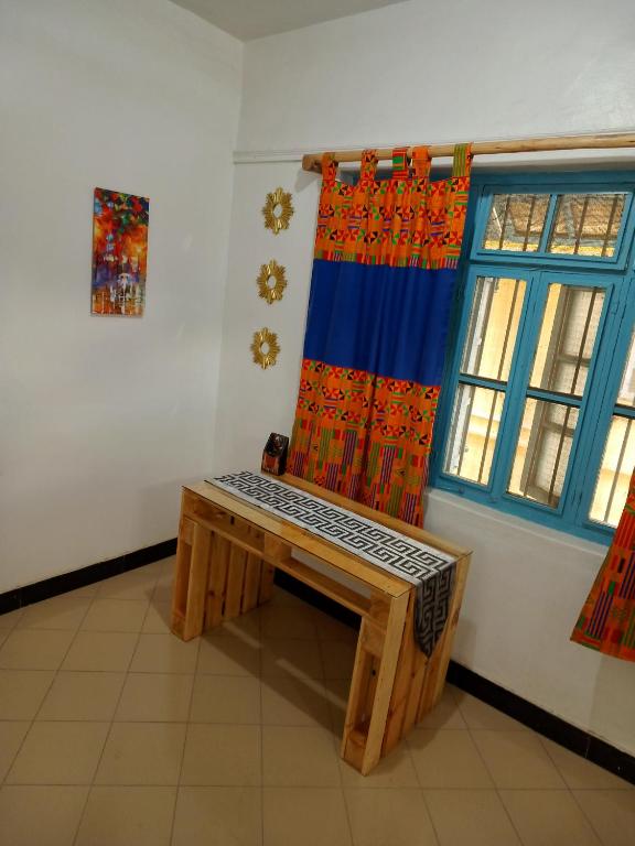 姆万扎Karibu Nyumbani, Welcome Home的窗户客房内的木凳