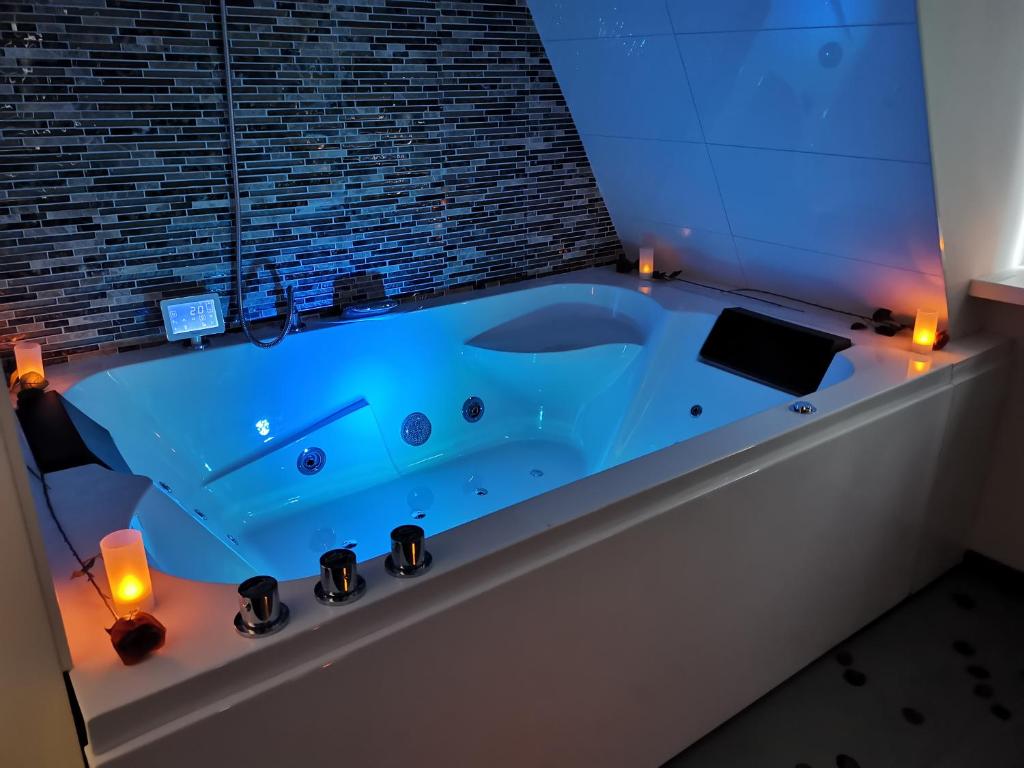 乌得勒支Wellness Suite Utrecht的浴室设有蓝色的浴缸,内配蜡烛