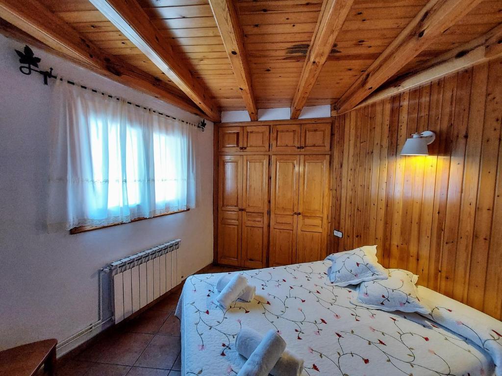 埃斯波特Camping Solau的一间卧室设有一张床和木制天花板