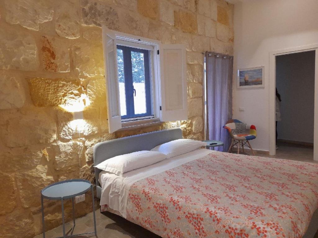 锡拉库扎Casa Maria的一间卧室设有一张床和石墙