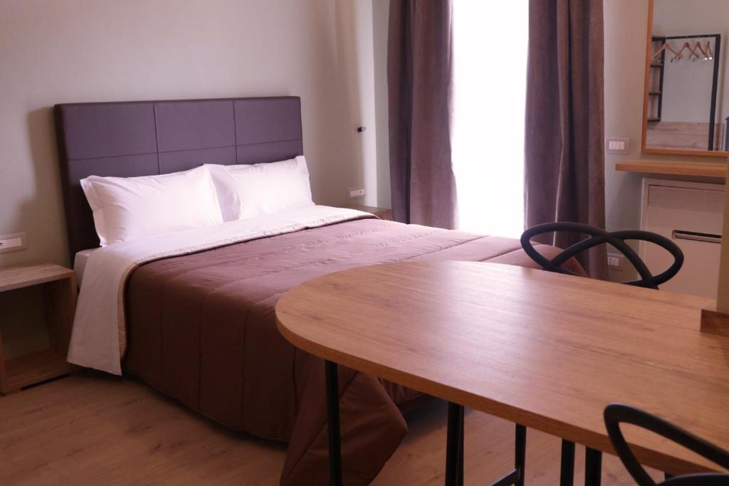 巴里Manhattan Room & Suite的酒店客房配有一张床铺和一张桌子。