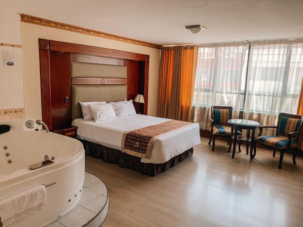 利马奥罗酒店 的酒店客房配有一张床和浴缸。
