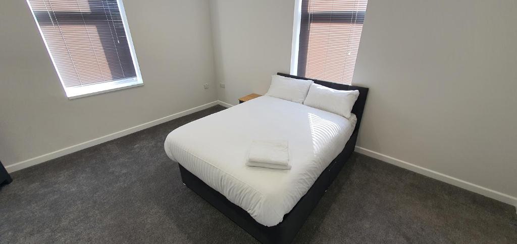 巴恩斯利APARTMENT in BARNSLEY CENTRAL的一间卧室配有带白色床单和枕头的床。