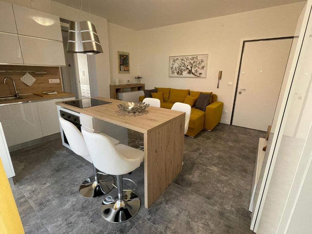 巴多利诺Magic Apartments的厨房以及带黄色沙发的客厅。