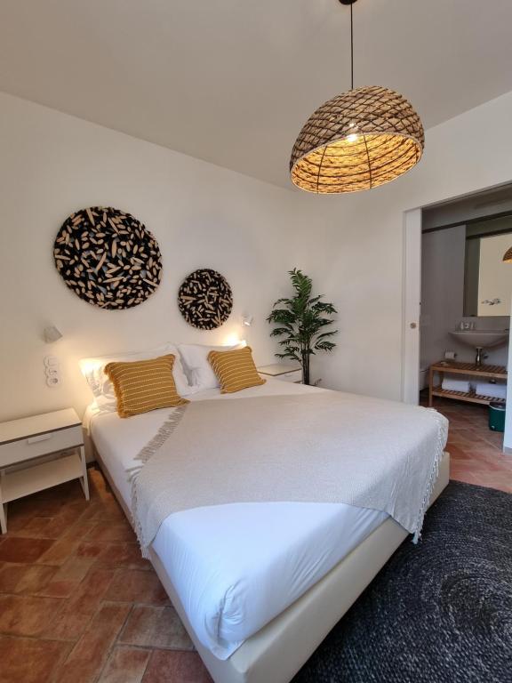 法鲁Casa Algarbe的一间卧室配有一张大白色的床和两个吊灯