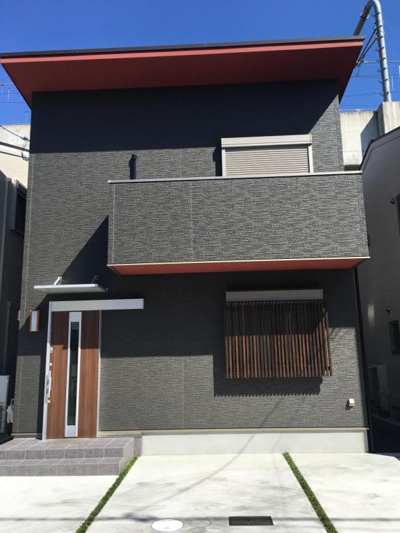 奈良Guesthouse Kaede Annex的黑色建筑,有红色屋顶