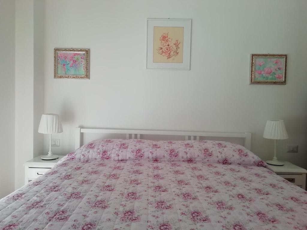 拉帕洛La Vie En Rose的一间卧室配有一张带粉红色床罩和两盏灯的床。