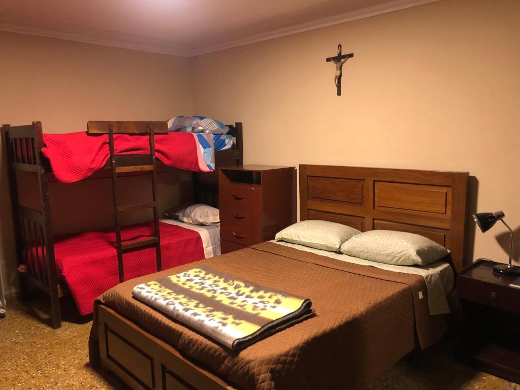 塔里哈Ballivian的卧室设有两张双层床,墙上有十字架