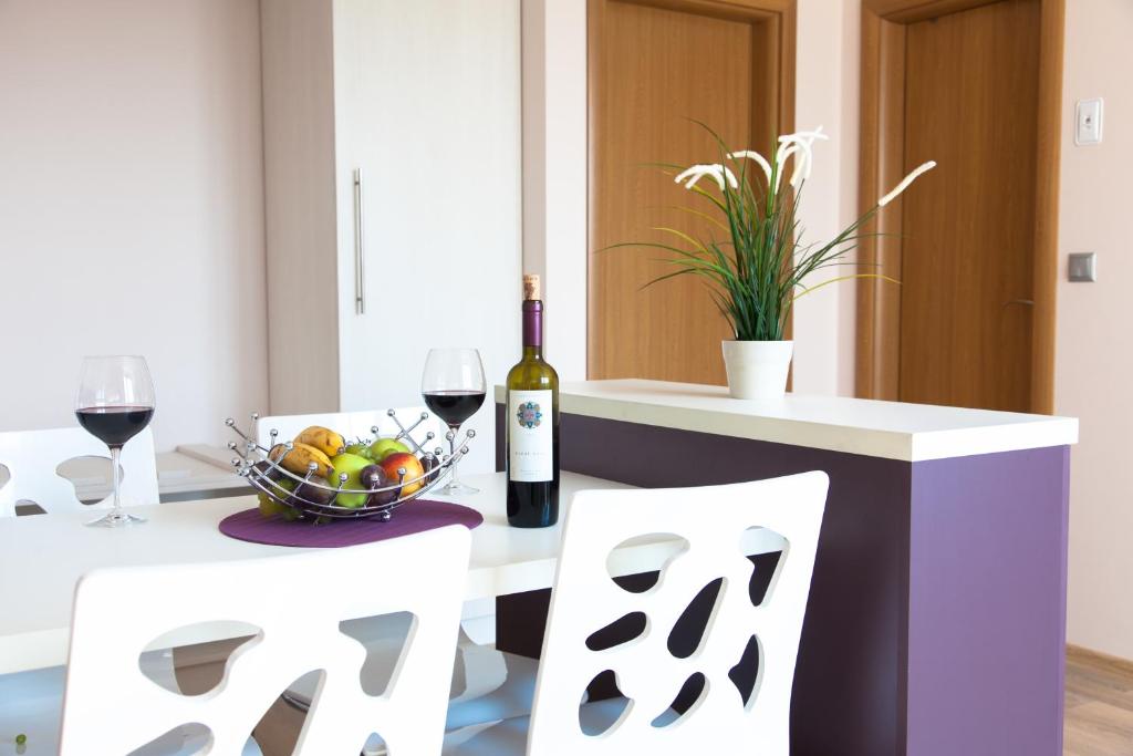 布拉戈耶夫格勒天空公寓酒店的一张桌子,上面放着一碗水果和一瓶葡萄酒