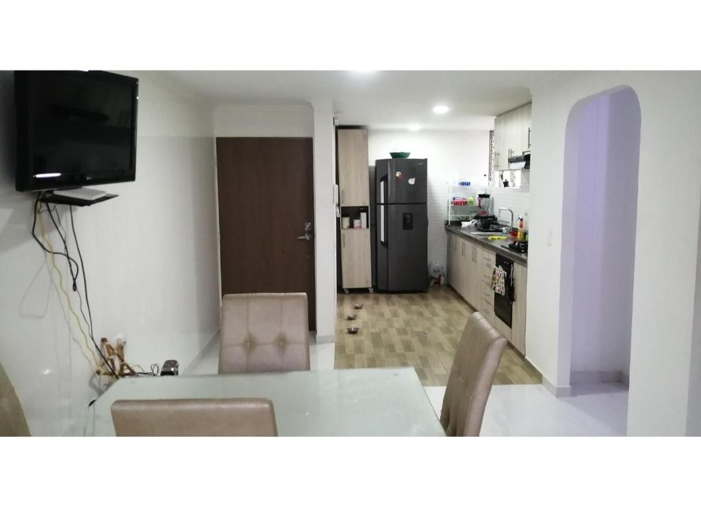 布卡拉曼加Habitación privada en apartamento con terraza的一间带桌子的厨房和一间带冰箱的厨房