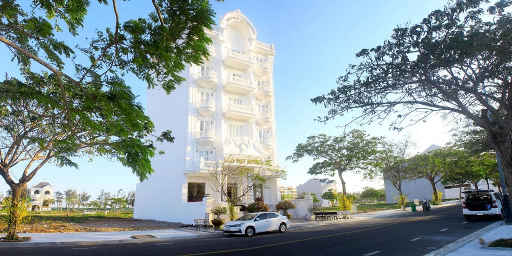 潘切Huy Đạt Hotel的停在大楼前的白色汽车