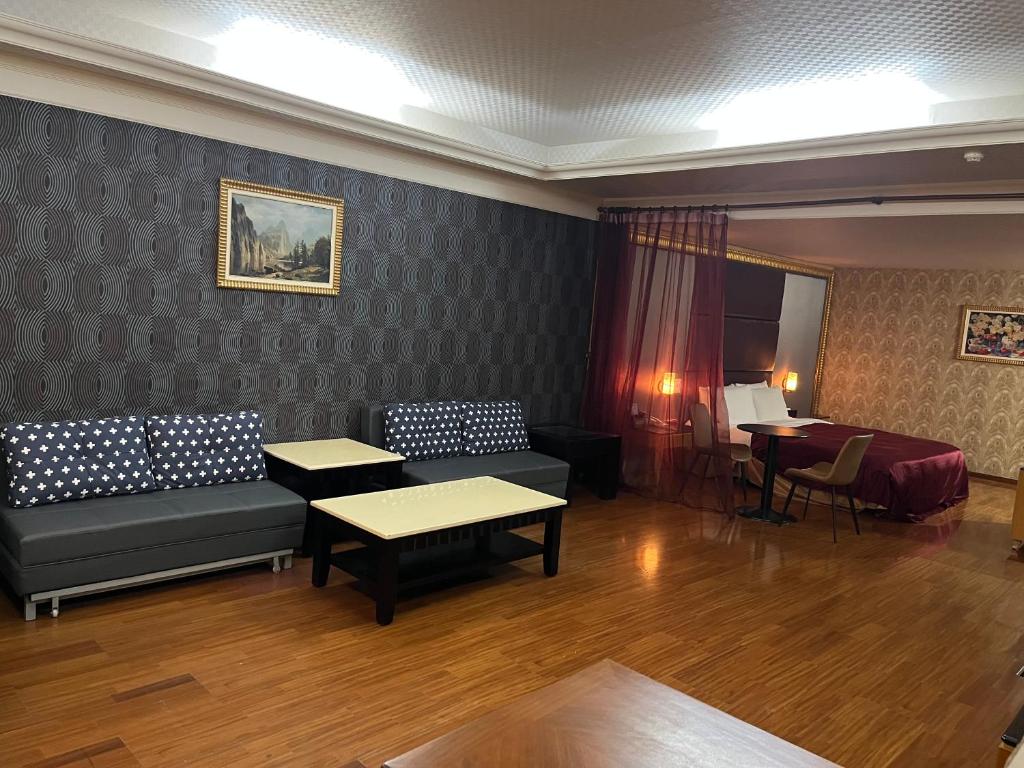 高雄花乡旅馆連鎖-凤山店的客厅配有沙发、桌子和书桌