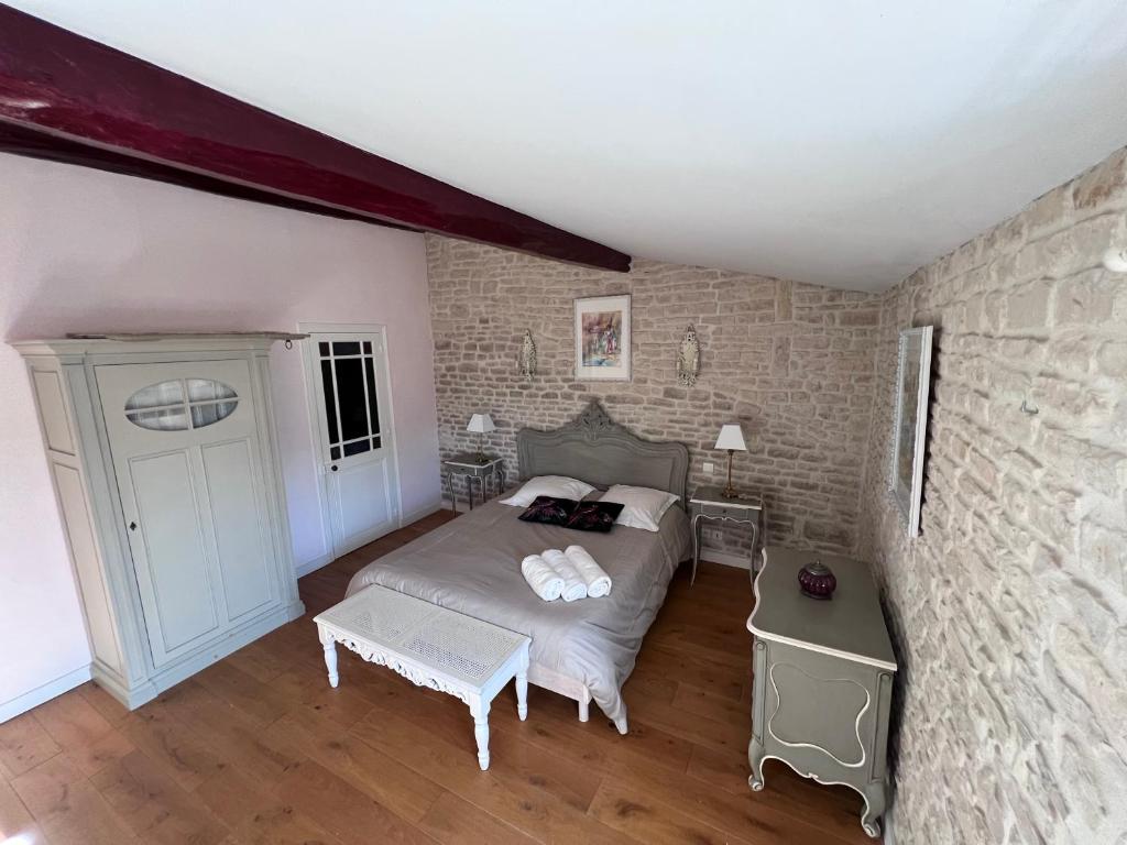 CourçonLe Puits Sainte Claire的一间卧室设有一张床和砖墙