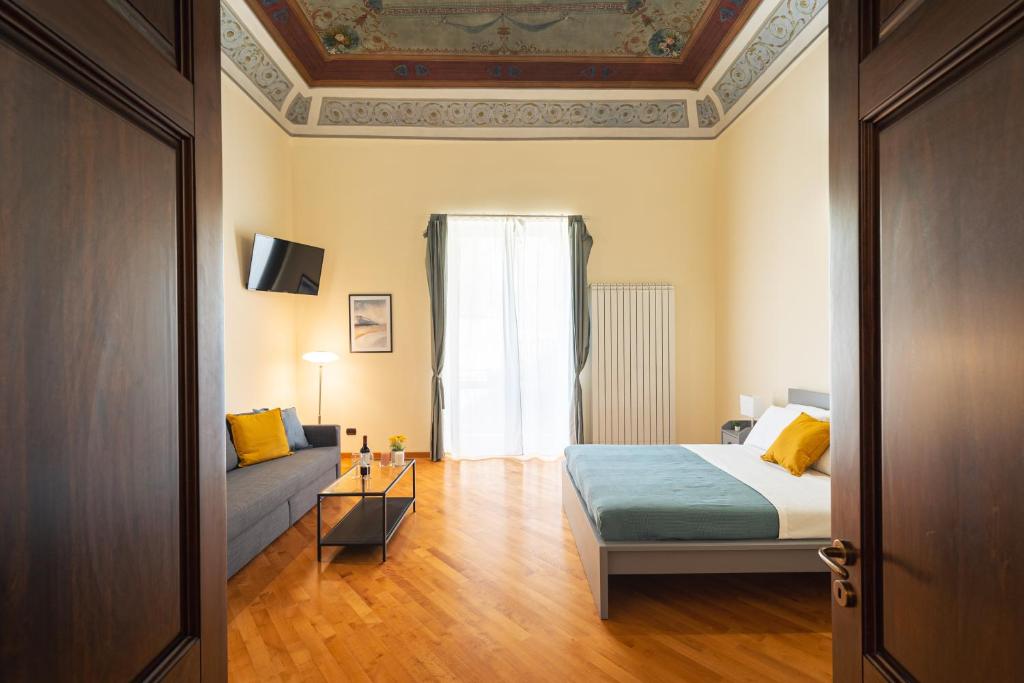 巴勒莫Open Sicily Homes "Residence ai Quattro Canti" - Self check in - Deposito Bagagli的一间卧室配有一张床、一张沙发和一个窗口