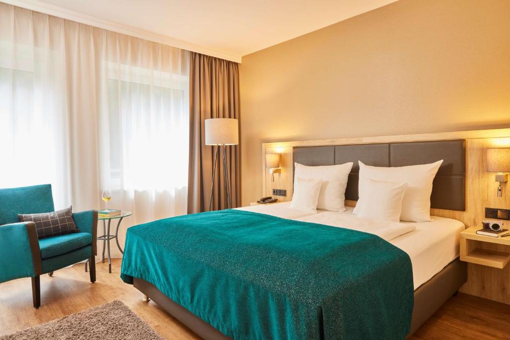 汉堡贝斯特韦斯特精品艾尔斯特尔克尔格酒店的酒店客房带一张大床和一把椅子