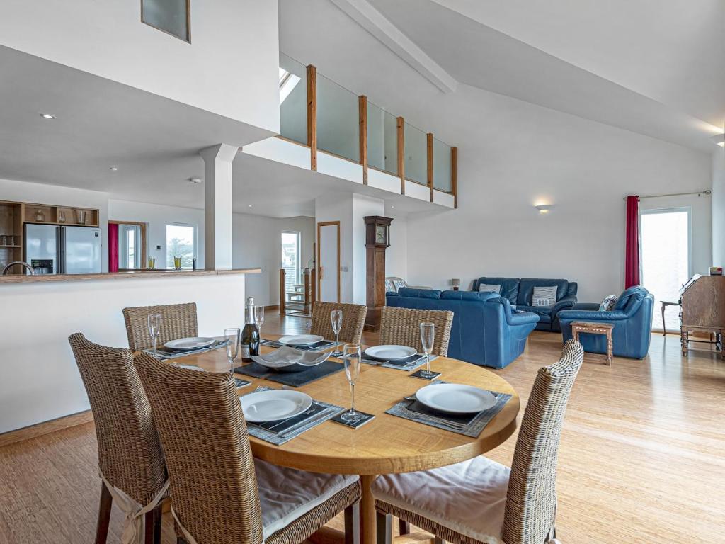 罗斯奈格尔Pass the Keys Celyn Y Mor Stunning Rhosneigr Family Beach House的一间带木桌和椅子的用餐室