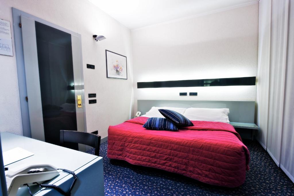 比耶拉米开朗基罗酒店的酒店客房,配有一张带红色毯子的床