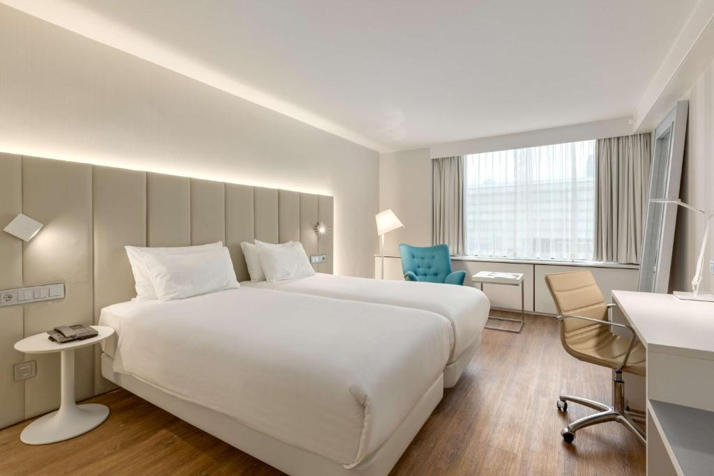 乌得勒支乌得勒支NH酒店的酒店客房设有一张白色大床和一张书桌