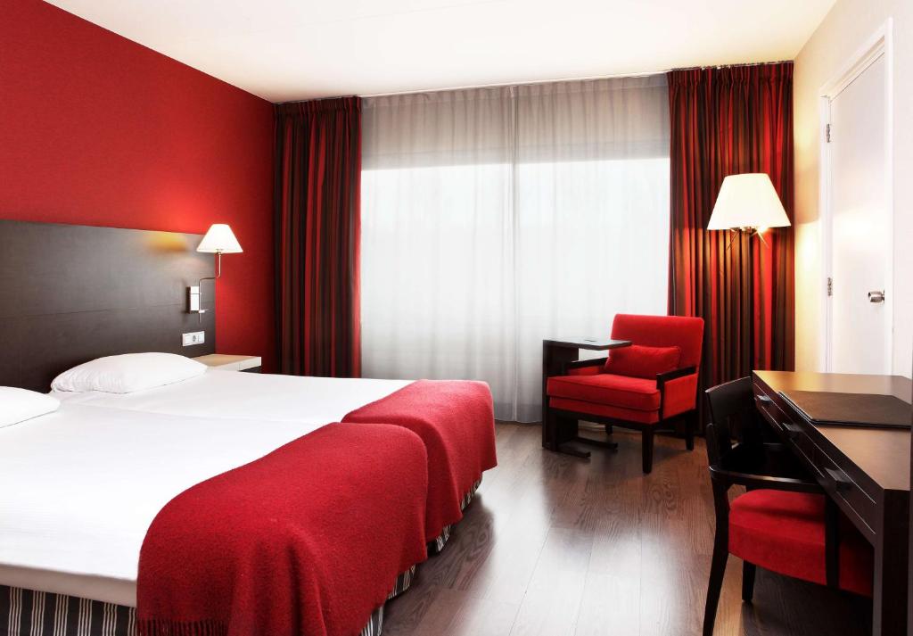 艾瑟尔河畔卡佩勒鹿特丹卡佩里NH酒店的酒店客房配有一张床、一张桌子和一把椅子。