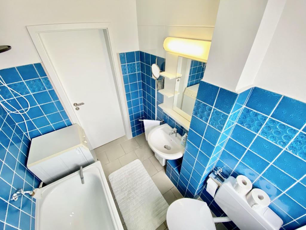 沃尔夫斯堡Zentral gelegene 2 Zi. Wohnung nähe Innenstadt/HBF的蓝色瓷砖浴室设有卫生间和水槽